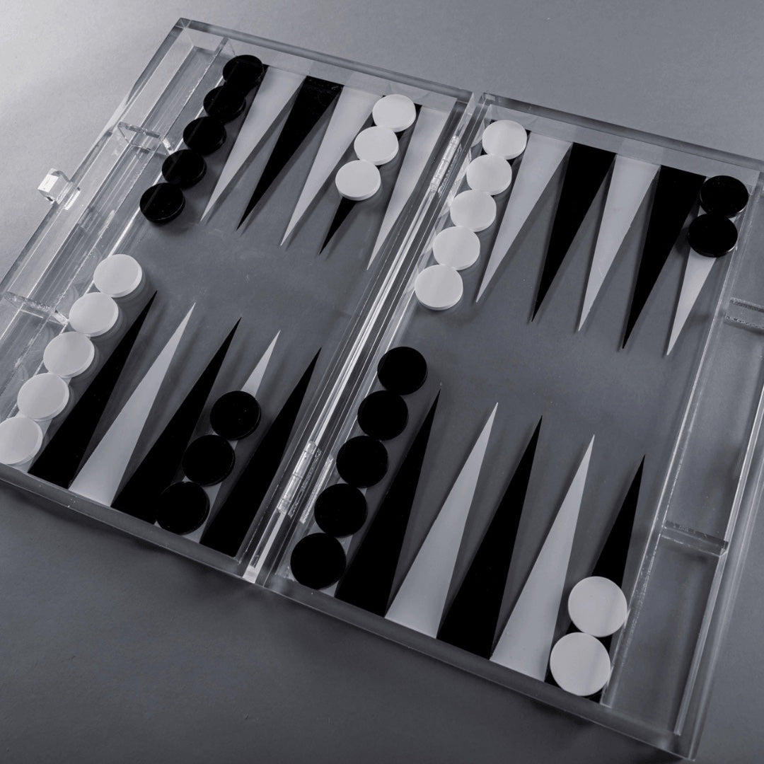 Eclectic contemporary acrylic backgammon set with black and white playing pieces on a clear board