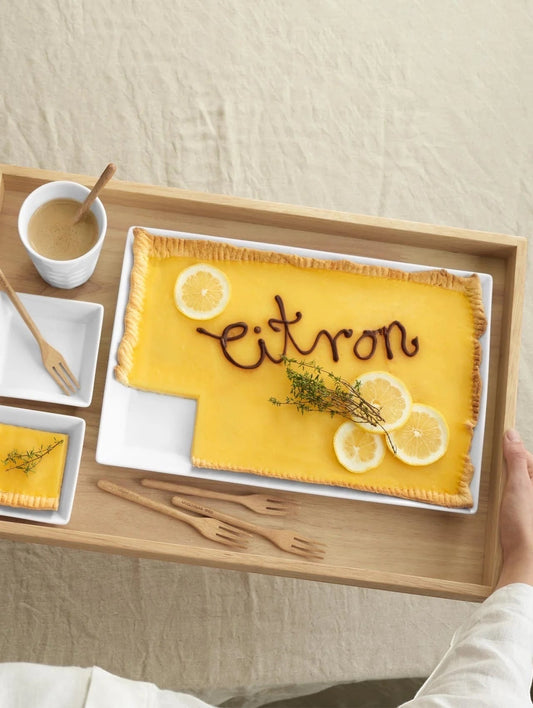 Eclectic ASA Selection white porcelain rectangular serving platter holding a lemon tart on a wooden tray