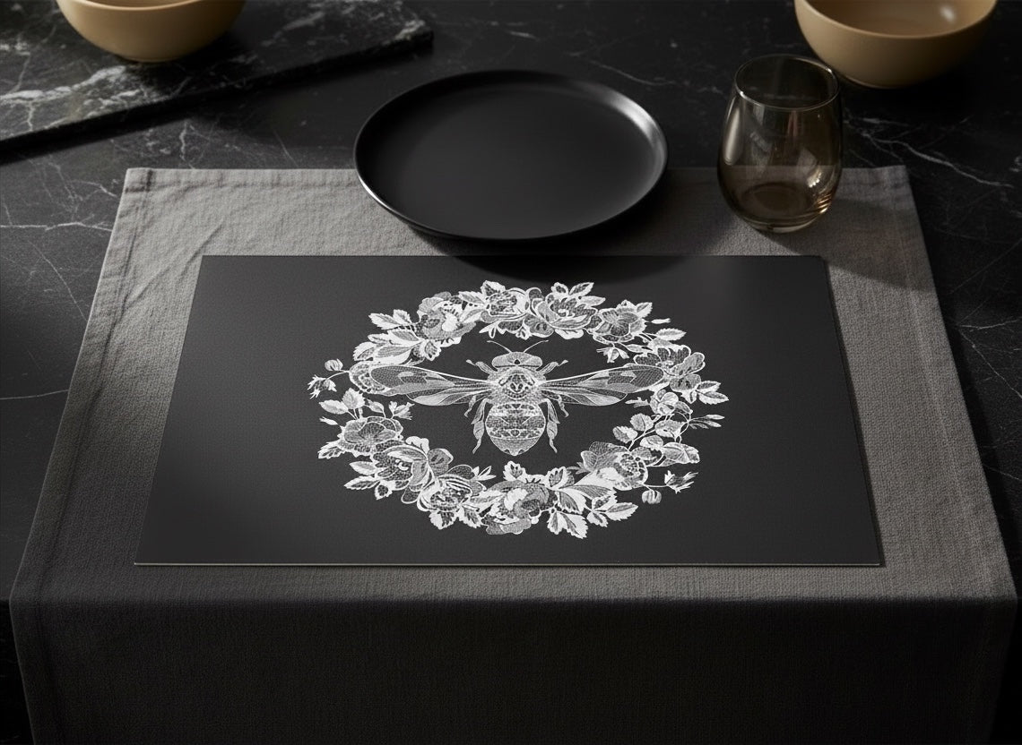 Eclectic black paper disposable placemat featuring an intricate white bee and floral wreath design on a table setting.