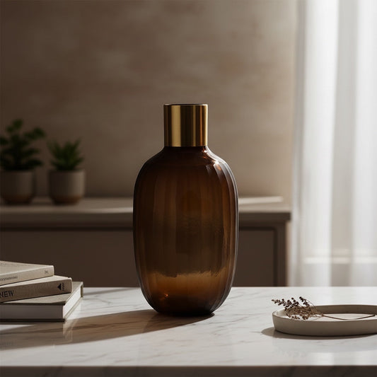 Eclectic brown glass vase with vertical texture and a brushed gold rim, standing on a marble table.