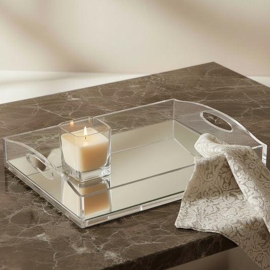 Eclectic clear acrylic gallery tray with a mirrored base, styled with a lit candle and lace cloth on a marble surface.