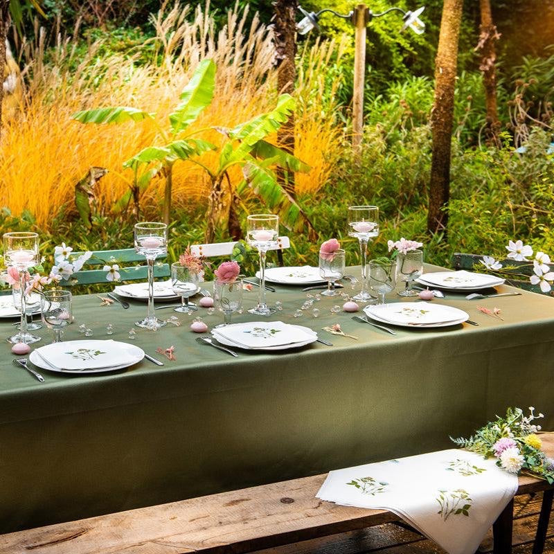 Eclectic Fleurs des Prés cocktail napkins with wildflower print on a garden table setting with green tablecloth