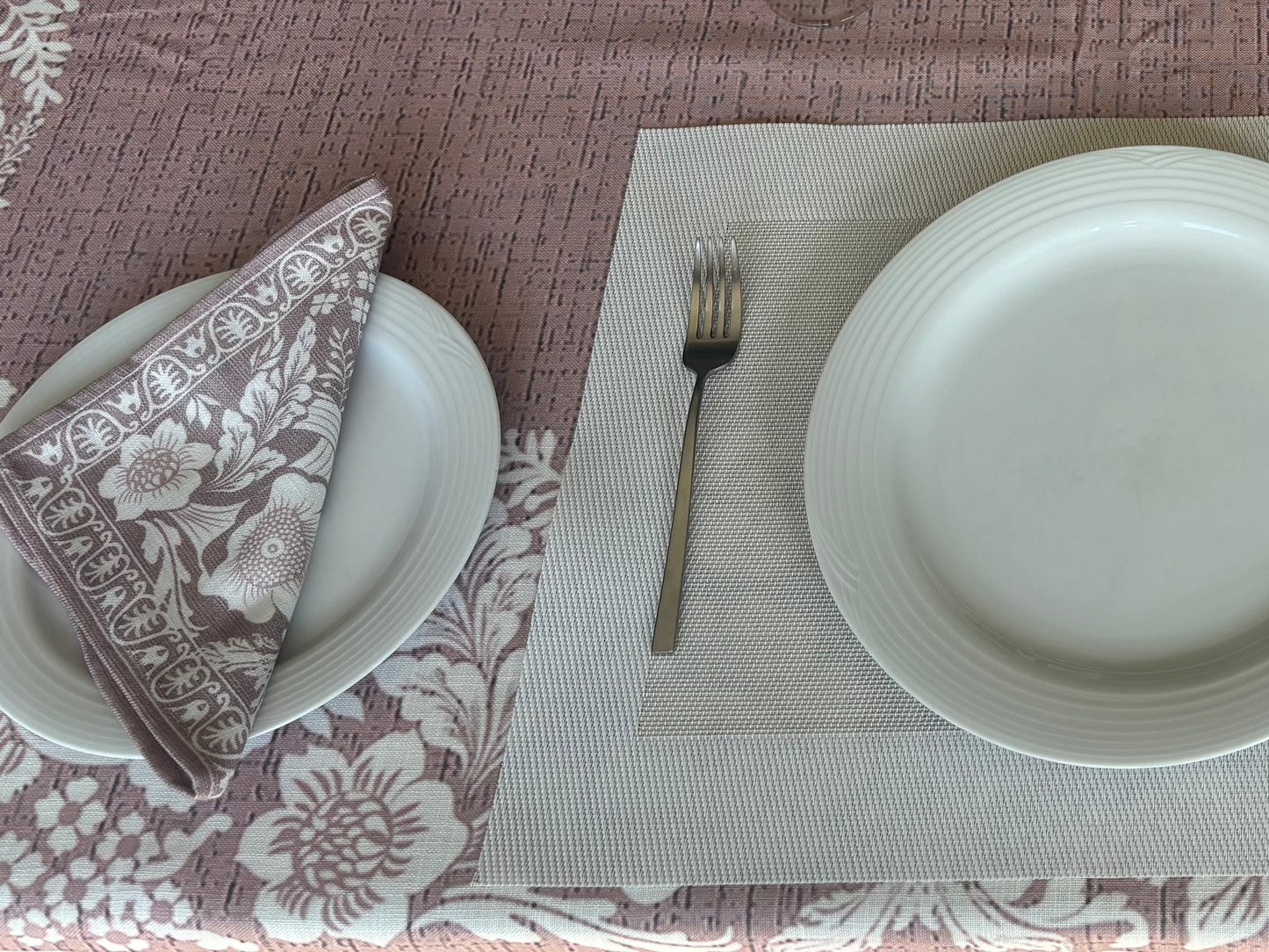 Eclectic floral dusty pink napkin set of 4 with white botanical motifs on a linen-look fabric table setting.