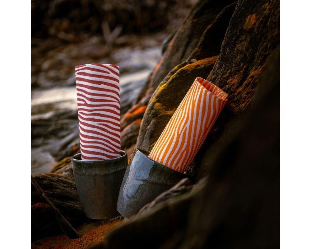 Eclectic Françoise Paviot Dune Terre airlaid dinner napkins with earthy striped patterns in ceramic cups outdoors
