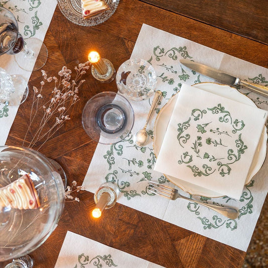 Eclectic Françoise Paviot Régence Vert airlaid dinner napkins with green botanical motifs on a wooden dining table.