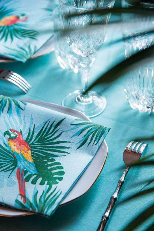 Eclectic Françoise Paviot Perroquet turquoise airlaid dinner napkin with parrot and tropical foliage print on table