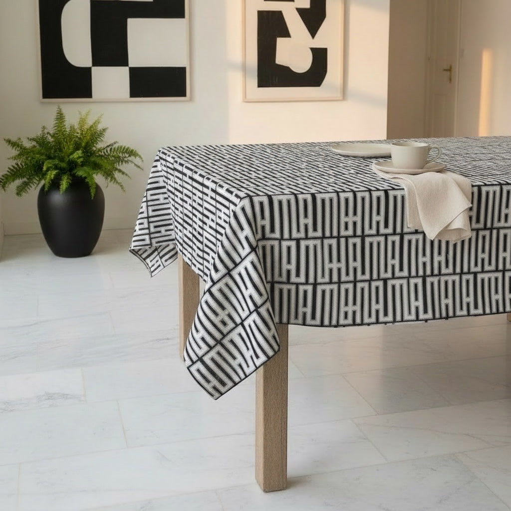 Eclectic black and white geometric linen-look tablecloth on a wooden dining table in a modern room.
