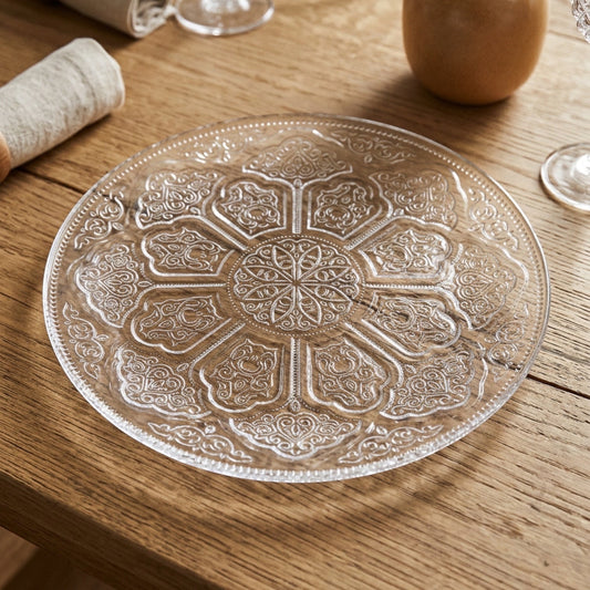 Eclectic Irena Crystal Shiraz 35cm clear glass charger plate with intricate embossed scrollwork on a wooden table.