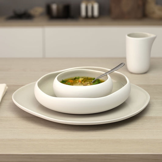 Eclectic Médard de Noblat Oslo stoneware condiment bowl in matte white and linen on a wooden table setting.