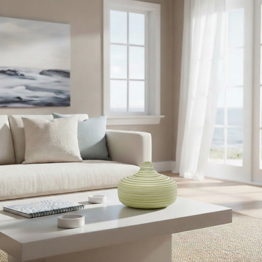 Eclectic wide olive ribbed glass vase on a white coffee table in a bright, contemporary living room setting.