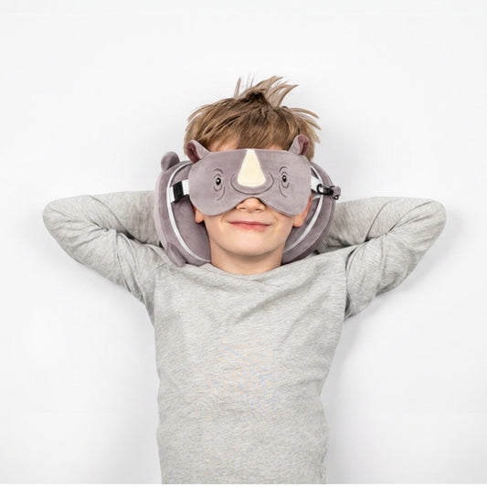 Eclectic child wearing a grey Remy the Rhino travel pillow and matching eye mask for comfortable travel rest