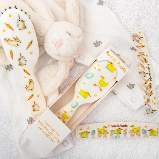 Eclectic Rock & Ruddle baby hairbrushes and combs featuring charming rabbit and duck illustrations on white handles.