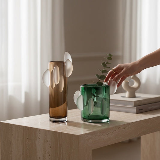 Eclectic Rosie green glass vase with frosted oval appliqués on a stone console table with a hand adjusting a stem