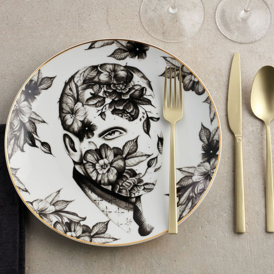 Eclectic Sambonet Rock Antique champagne cutlery set with a fork, knife, and spoon beside a floral portrait plate.