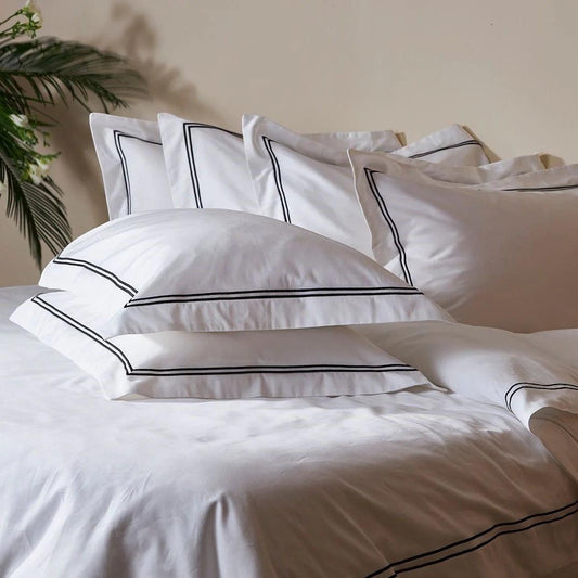 Eclectic Saxon white cotton sateen duvet set with elegant black satin-stitched double border on bed