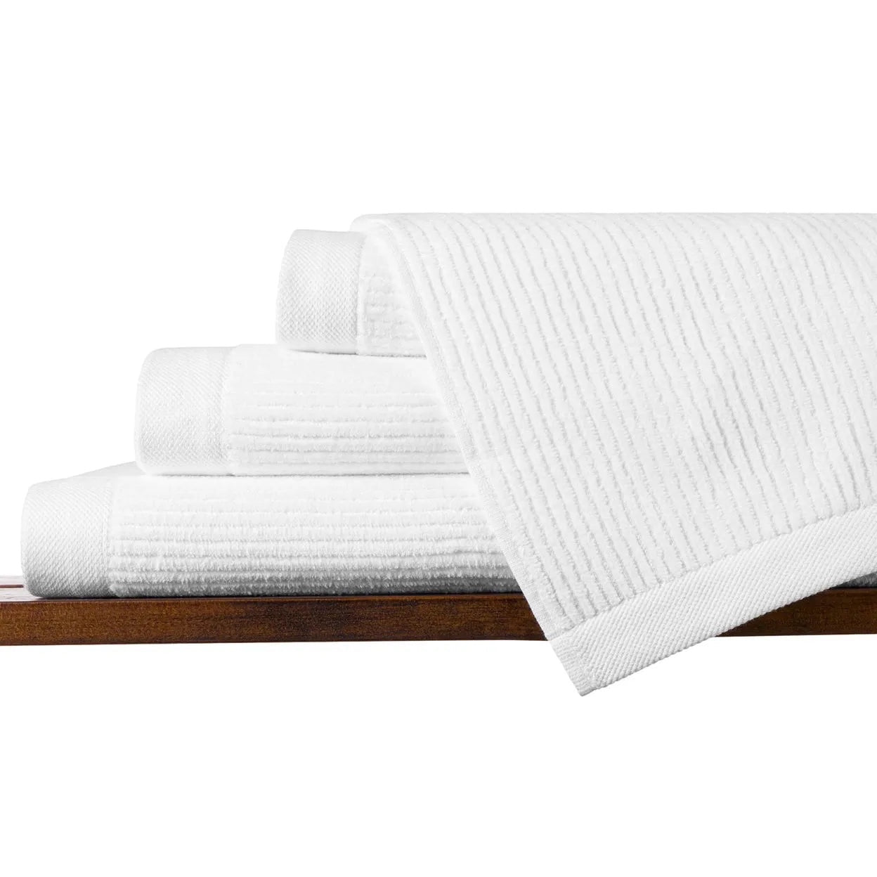 Eclectic white velvet cotton guest towel with a soft ribbed texture, stacked neatly on a wooden shelf.