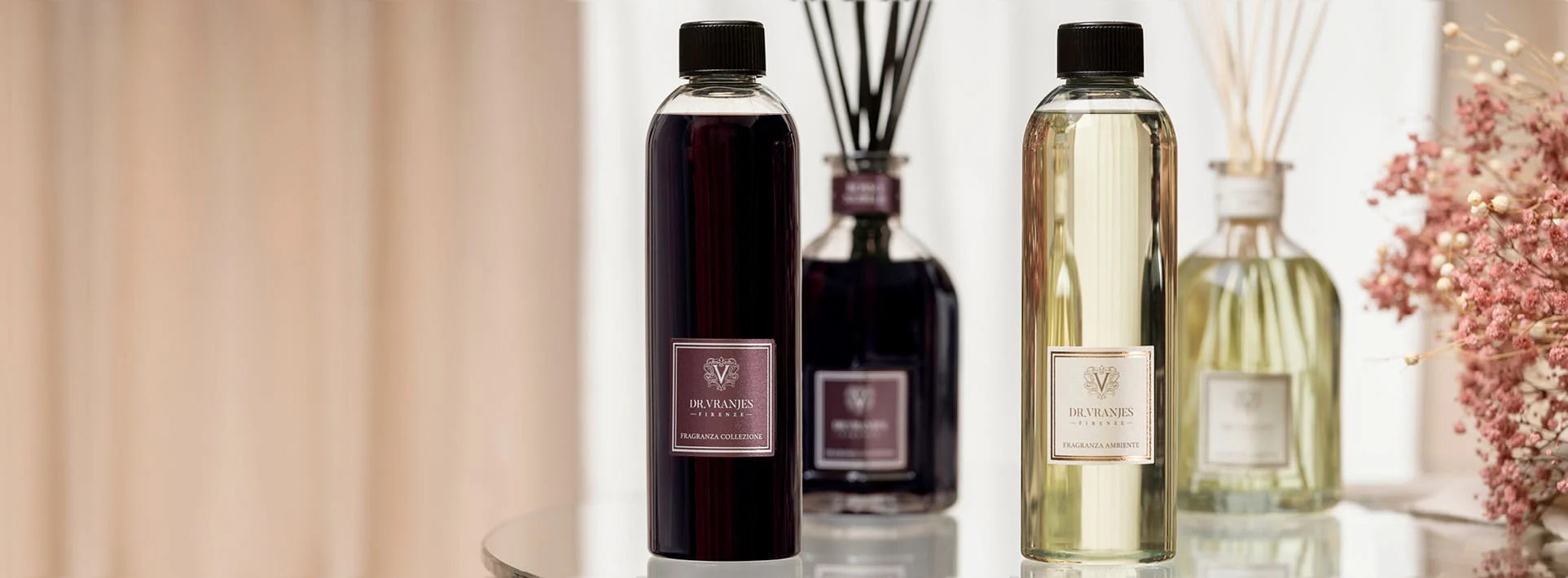 Dr Vranjes diffuser refill bottles displayed with reed diffusers and dried flowers.
