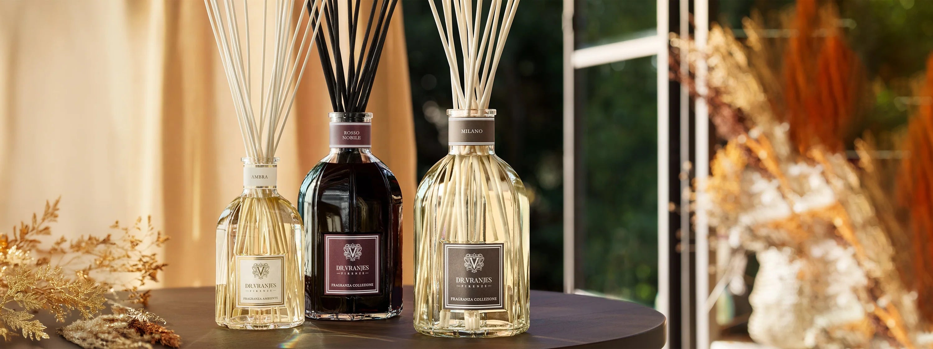 Dr Vranjes diffusers with reed sticks displayed on a table in a warm interior setting.