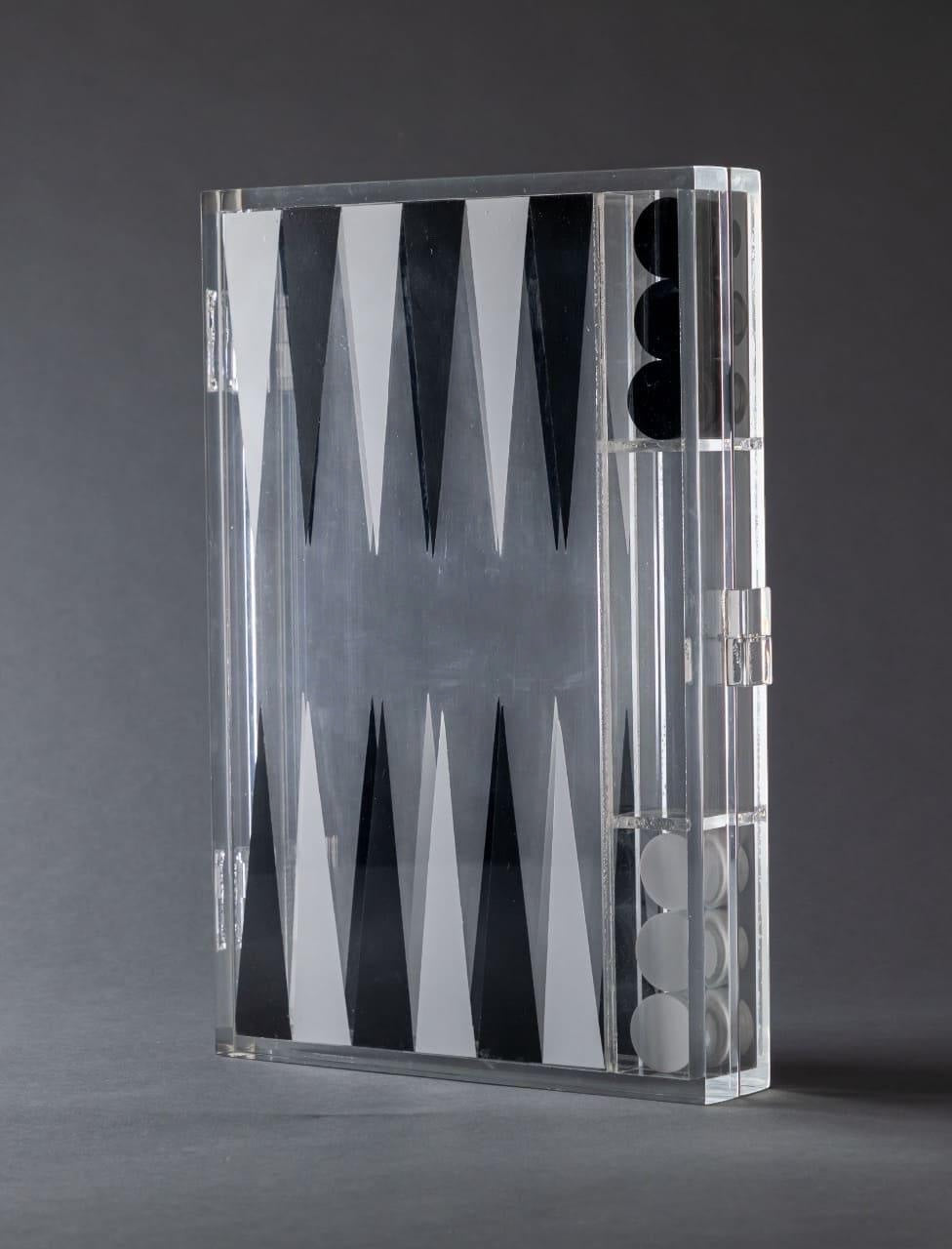 Eclectic modern acrylic backgammon set in a closed, transparent case with black and white geometric game pieces.