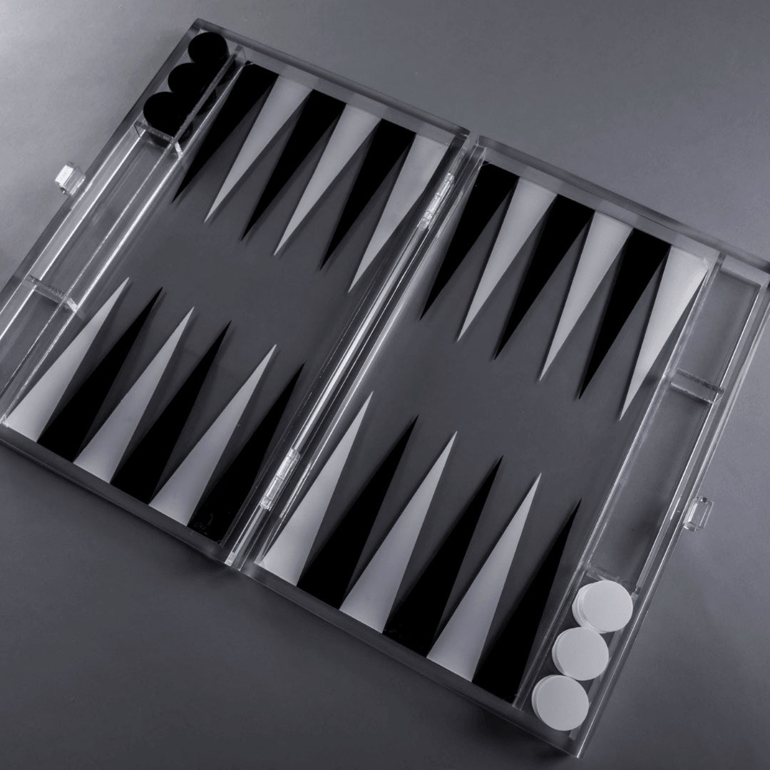 Eclectic modern acrylic backgammon set with a clear frame and contrasting black and white triangular points.
