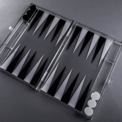 Eclectic modern acrylic backgammon set with a clear frame and contrasting black and white triangular points.