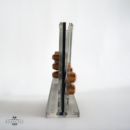 Eclectic clear acrylic espresso pod stand holding coffee capsules, viewed from the side on a white background.
