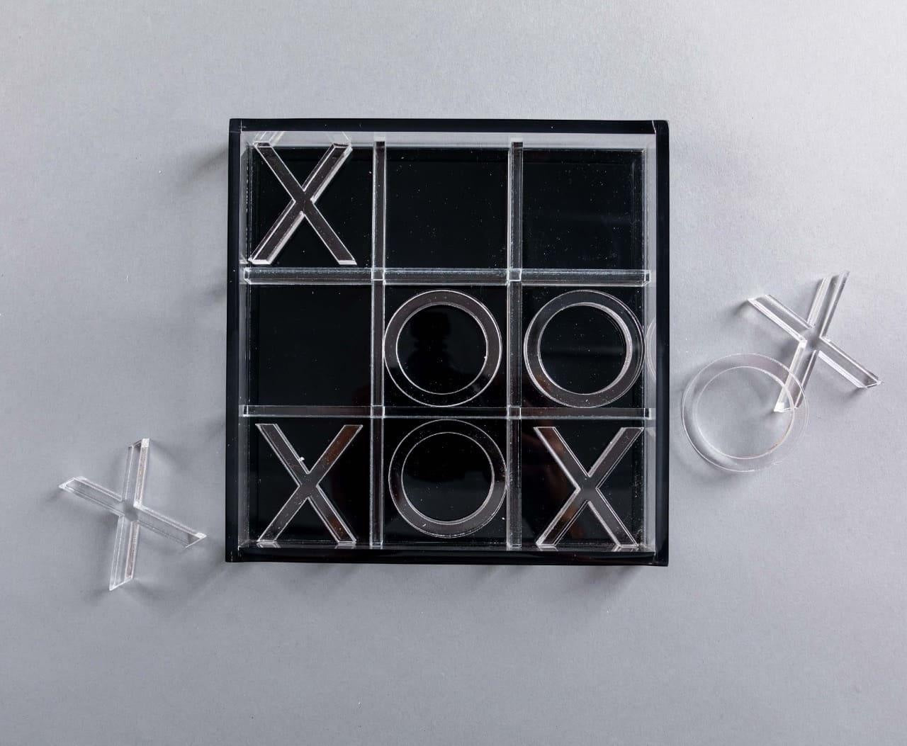Eclectic modern acrylic noughts and crosses game set with clear and black pieces on a grey background