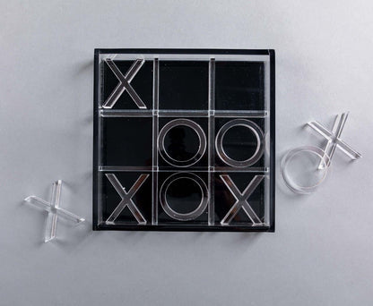 Eclectic modern acrylic noughts and crosses game set with clear and black pieces on a grey background