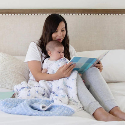 Eclectic Aden + Anais Rising Star cotton muslin dream blanket draped over a mother and baby reading a book in bed