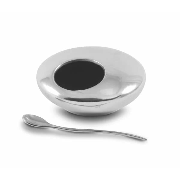 Eclectic aluminium mustard bowl and matching stainless steel spoon for serving condiments or salt on a table.