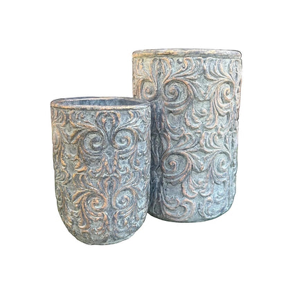 Eclectic antique-style cement planters with intricate scrollwork and an aged green patina with bronze undertones.