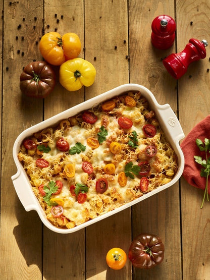 Eclectic Appolia rectangular ceramic oven dish in ecru filled with a baked pasta dish on a rustic wooden table