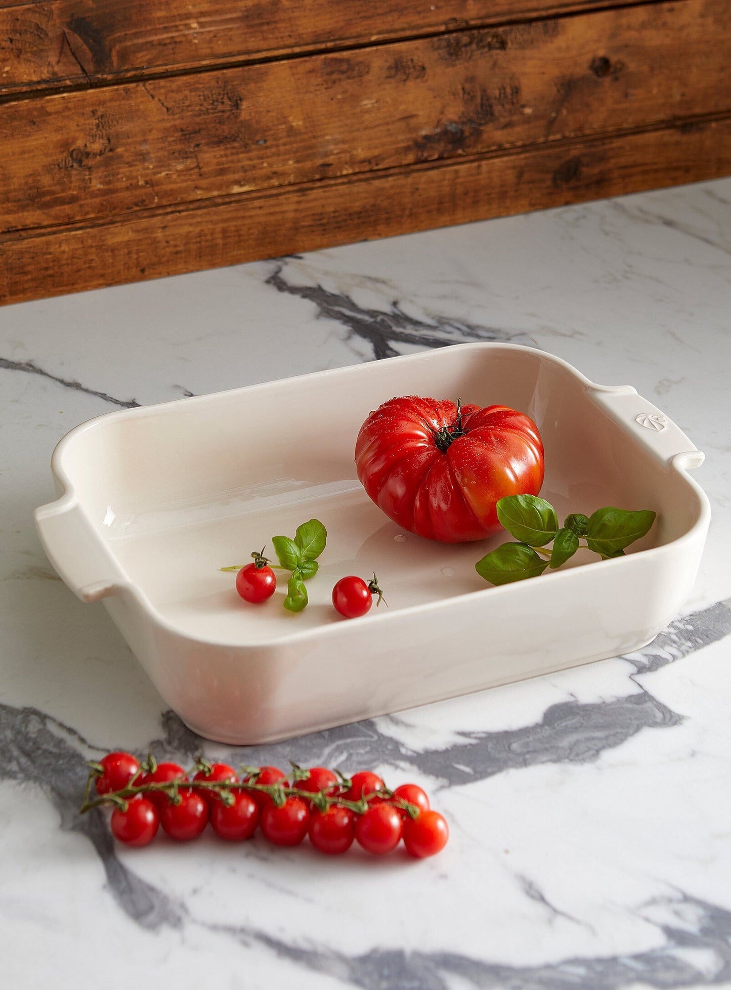 Eclectic Appolia square ceramic oven dish in ecru cream with ribbed handles, displayed on a marble countertop.