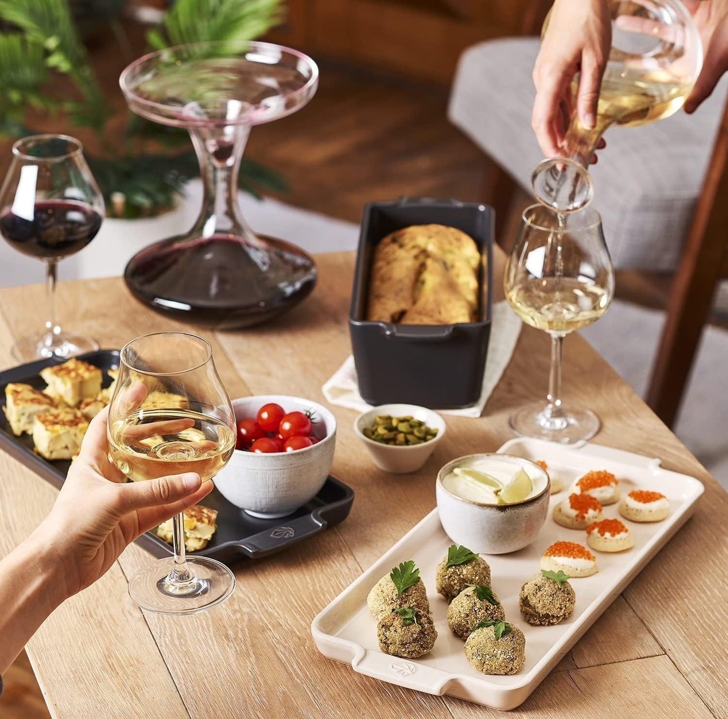 Eclectic Appolia ecru ceramic appetizer platter on a dining table with wine and snacks