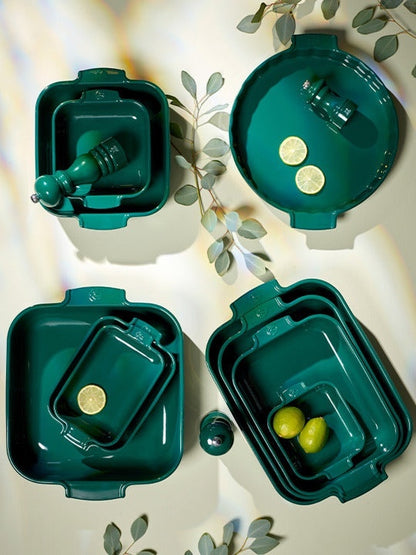 Eclectic collection of forest green Appolia ceramic oven dishes in various shapes and sizes with lemon accents