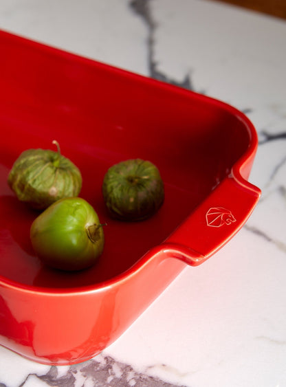 Eclectic Appolia red ceramic square oven dish with ribbed handles and tomatillos on a marble countertop