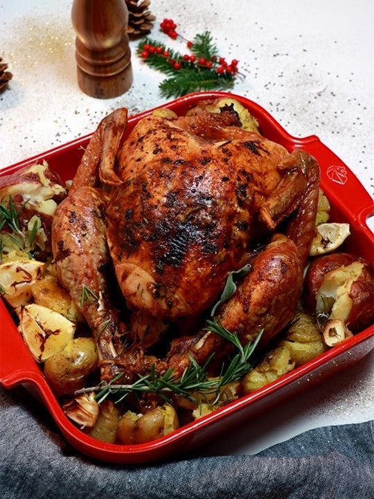 Eclectic Appolia red square ceramic oven dish filled with a roasted chicken and potatoes for a festive meal
