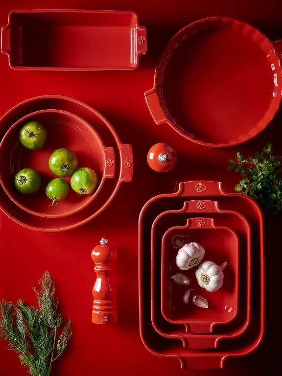 Eclectic Appolia rich red ceramic oven dishes and bakeware set arranged on a matching red surface with fresh produce