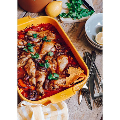 Eclectic Appolia saffron yellow rectangular ceramic oven dish filled with roasted chicken and vegetables on a table