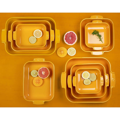 Eclectic Appolia saffron yellow ceramic oven dishes in various rectangular and square sizes with citrus fruit slices.