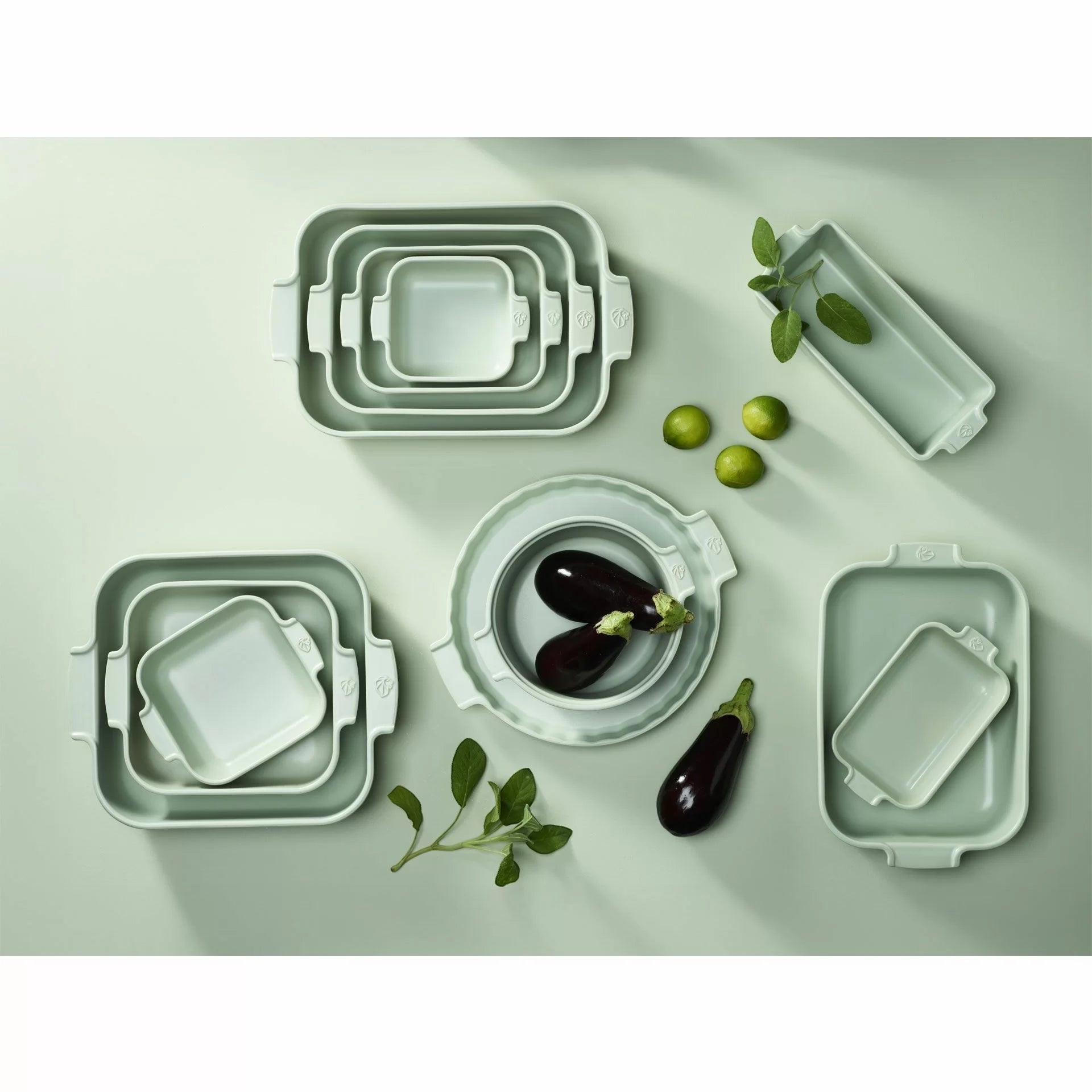Eclectic Appolia sage green ceramic oven dishes in various rectangular and round sizes with fresh produce.