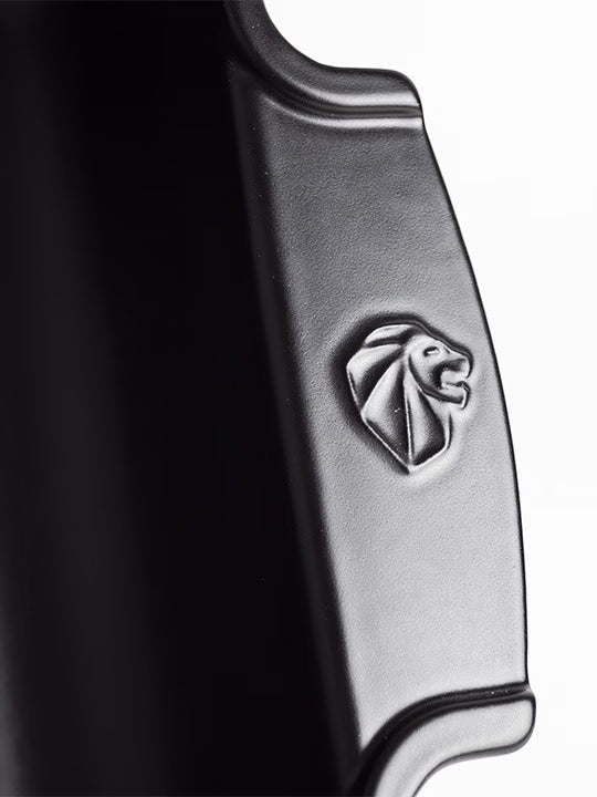 Close-up of the Eclectic Appolia satin black ceramic oven dish handle featuring an embossed lion logo detail.