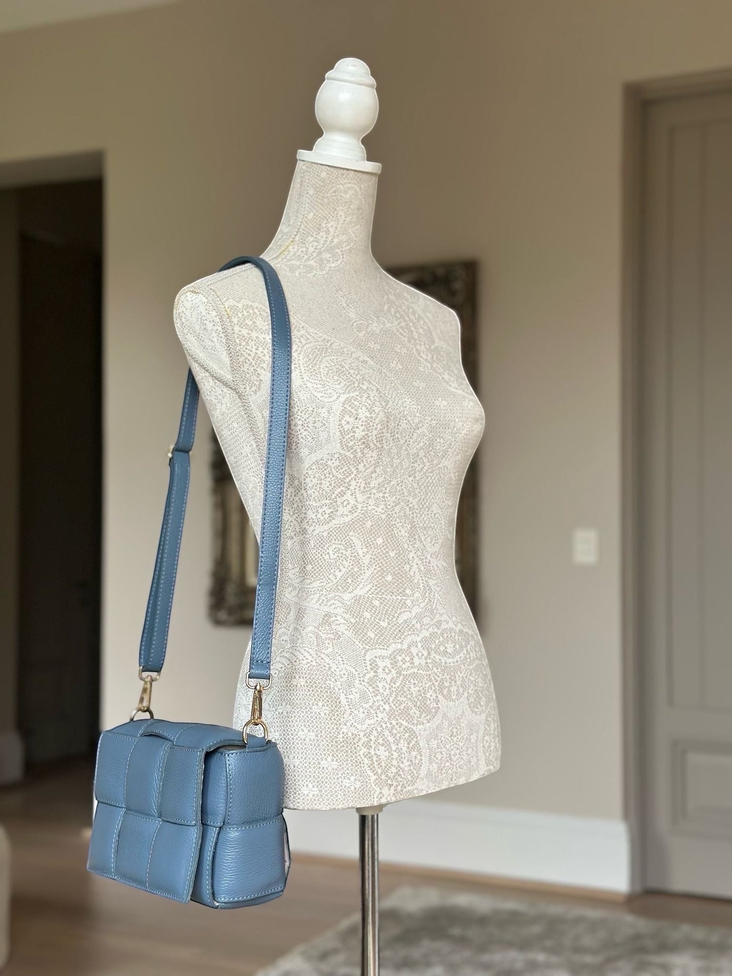 Eclectic Aria blue quilted leather box crossbody bag with gold hardware on a mannequin