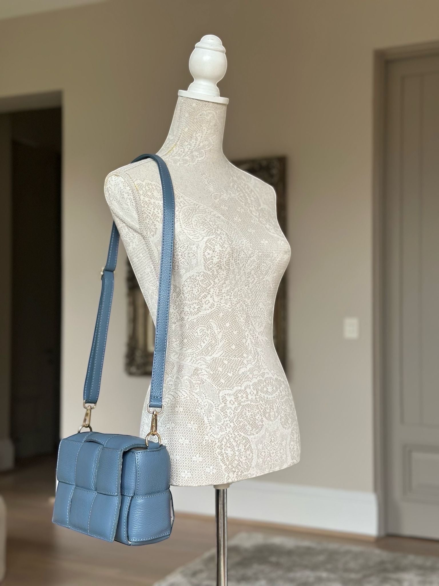 Eclectic Aria blue quilted leather box crossbody bag with gold hardware on a mannequin
