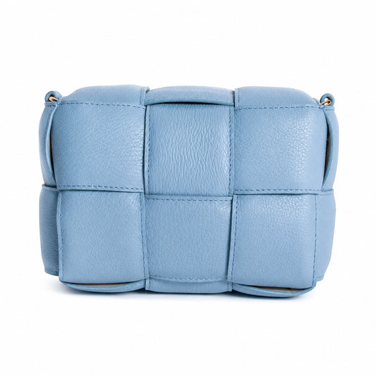 Eclectic Aria blue quilted leather box crossbody bag with a woven padded texture and gold-tone hardware.