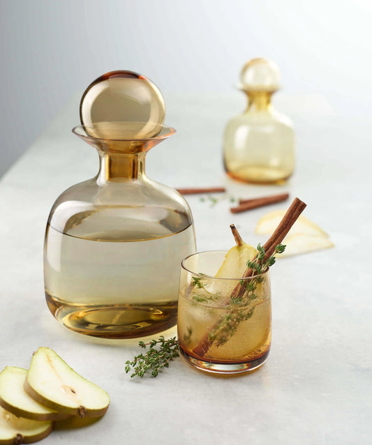 Eclectic ASA Selection Sarabi amber mouth-blown glass carafe with spherical stopper and matching glass on a table
