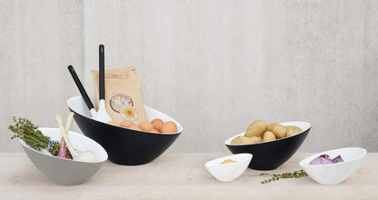 Eclectic ASA Selection Grande asymmetric bowls in black, white, and grey porcelain arranged on a wooden surface.