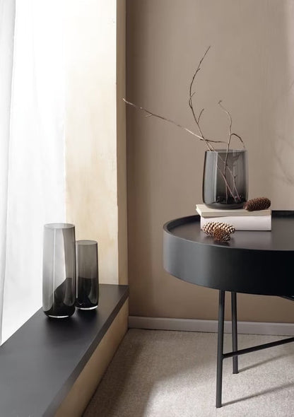 Eclectic ASA Selection Ajana smoky grey mouth-blown glass vases styled as candle holders on a modern table and ledge.
