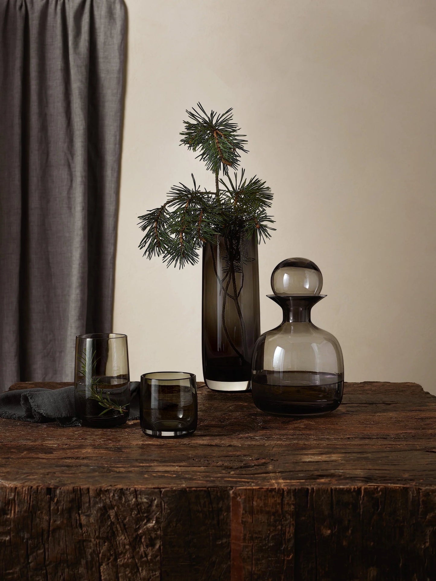 Eclectic ASA Selection Ajana smoky grey mouth-blown glass vase with a tall cylindrical shape on a rustic wooden table