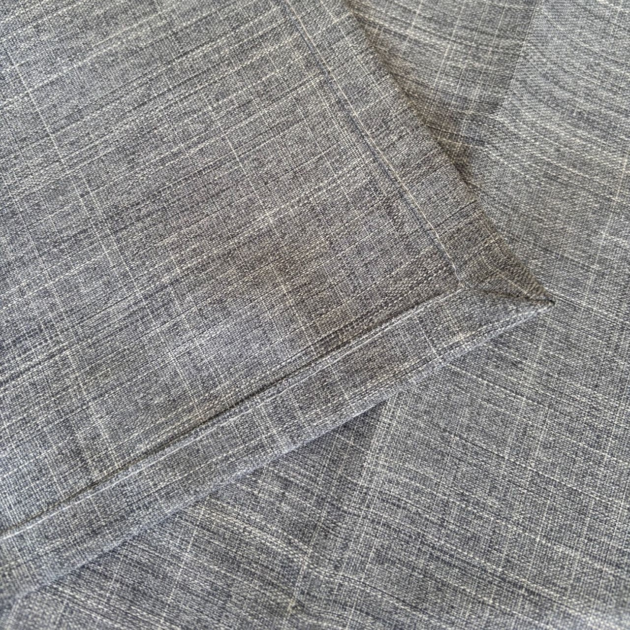 Eclectic ash grey linen-look polyester table runner with a detailed view of the woven fabric texture and stitched hem.